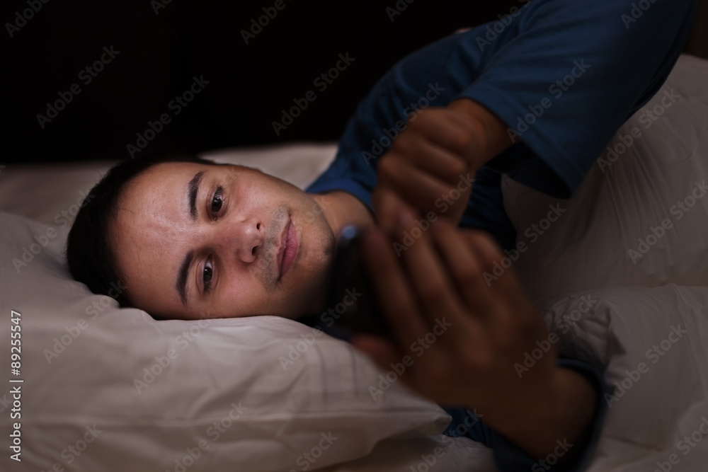 Man using his phone in the bed Man using his phone in the bed