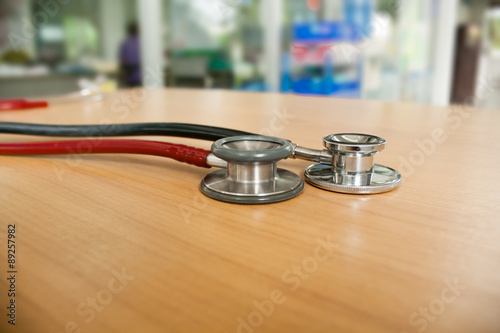 Still Life-Stethoscope 2 a black and red, placed on a wooden floor. medical equipment.