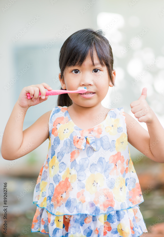 dental hygiene. happy little asian girl brushing her teeth dental hygiene. happy little asian girl brushing her teeth