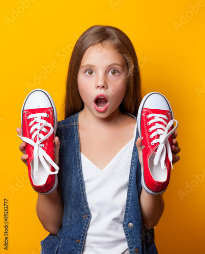 Young surprised girl with red gumshoes photo