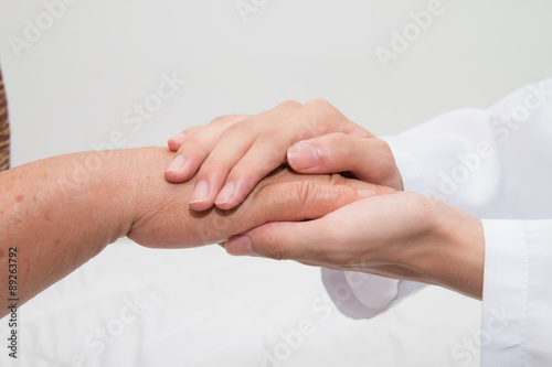 Doctor holding an old woman's hand
