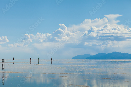 Persone all'orizzonte nel Salares de Uyuni, Bolivia . Montagne all'orizzonte photo