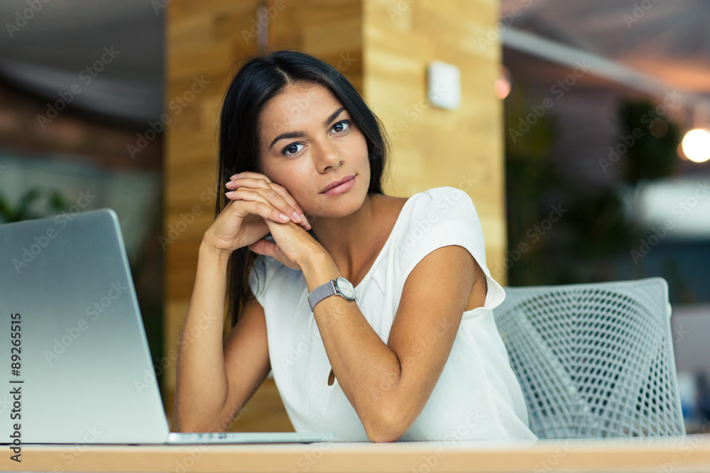 Portrait of attractive thoughtful businesswoman sitting in office Portrait of attractive thoughtful businesswoman sitting in office