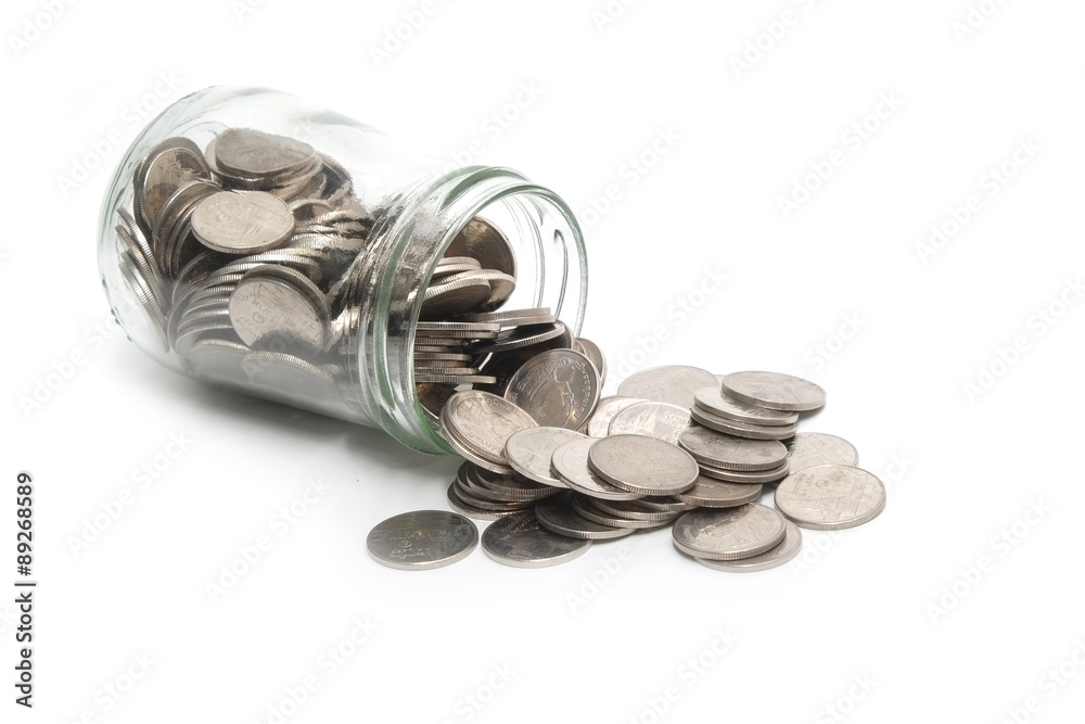 Jar of thai coins spilled on a white background Jar of thai coins spilled on a white background