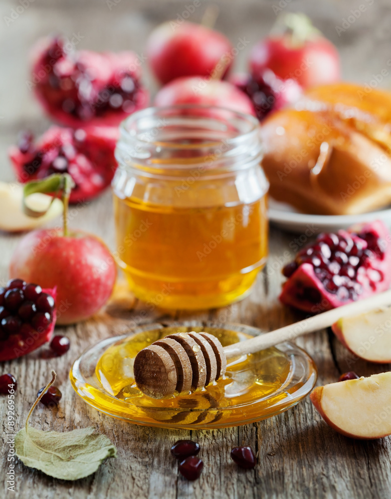 Honey, apple, pomegranate and hala, table set with traditional food for Jewish New Year Holiday, Rosh Hashana Honey, apple, pomegranate and hala, table set with traditional food for Jewish New Year Holiday, Rosh Hashana