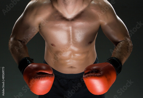 Muscular young caucasian boxer wearing boxing gloves
