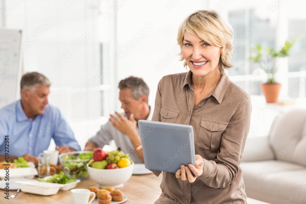 Smiling casual businesswoman using tablet at lunch Smiling casual businesswoman using tablet at lunch