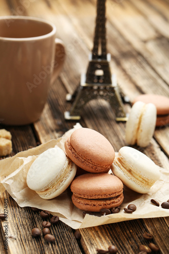 Coffee macarons with coffee beans on brown wooden background