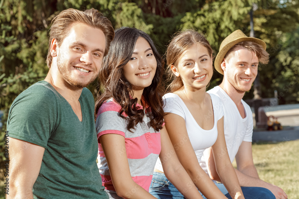 Four students smiling warmly into the camera Four students smiling warmly into the camera