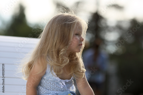 Beautiful blonde little girl 3 years old in a park 