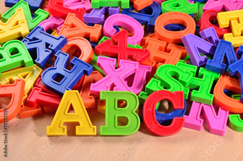 Plastic colored letters ABC on a wooden background