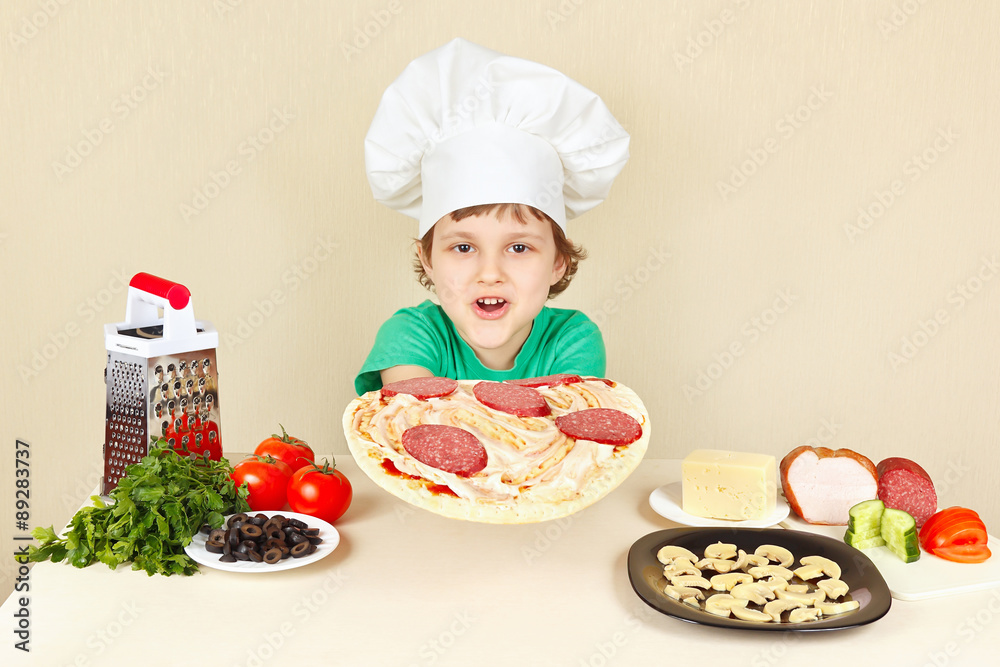 Little funny chef puts sausage on the pizza crust Little funny chef puts sausage on the pizza crust