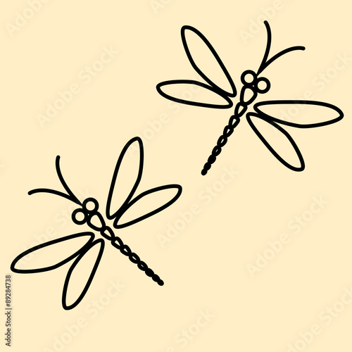 Two vector dragonflies silhouettes on the creamy background