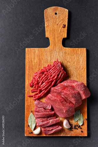Fresh butcher cut meat assortment on black background