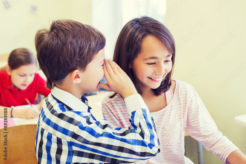 smiling schoolboy whispering to classmate ear smiling schoolboy whispering to classmate ear