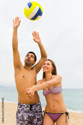 Couple playing with a ball on the beach