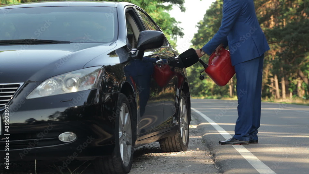 Businessman on the road with a jerrycan Businessman on the road with a jerrycan