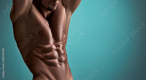 Attractive male body builder on blue background