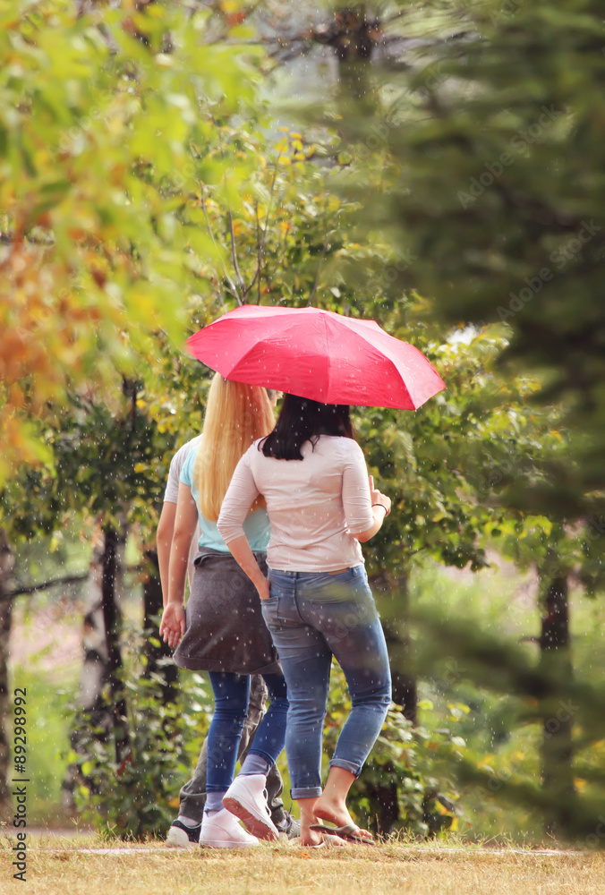 Friends walking with umbrella