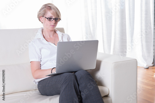 young attractive woman working with laptop on couch