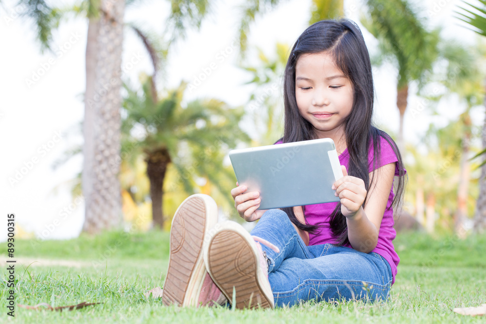 Fototapeta premium Asian little girl with a Tablet