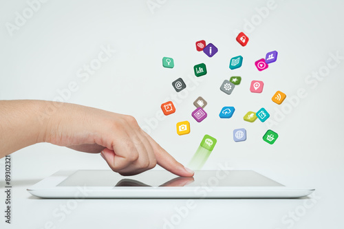 woman touching application icons fly off the tablet computer photo