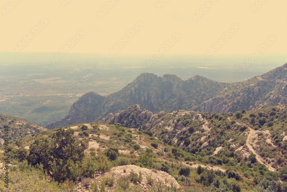 Panoramic view on the rugged landscape of the Montserrat mountain, in Catalonia, Spain. Image filtered in faded, washed out, retro, style with soft focus; nostalgic vintage travel concept.