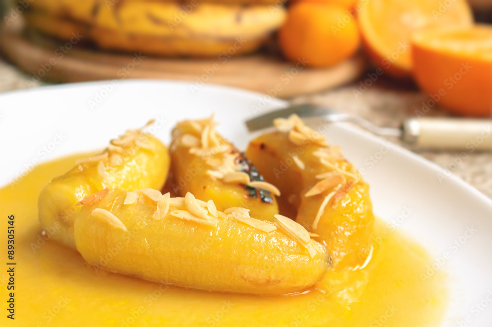 Bananas flambe with nuts on a white plate Bananas flambe with nuts on a white plate