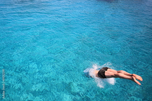 man diving into blue waters