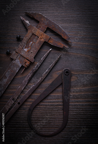 Rusty vernier calipers on vintage wooden board