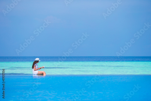Young woman reading book during tropical white beach © travnikovstudio