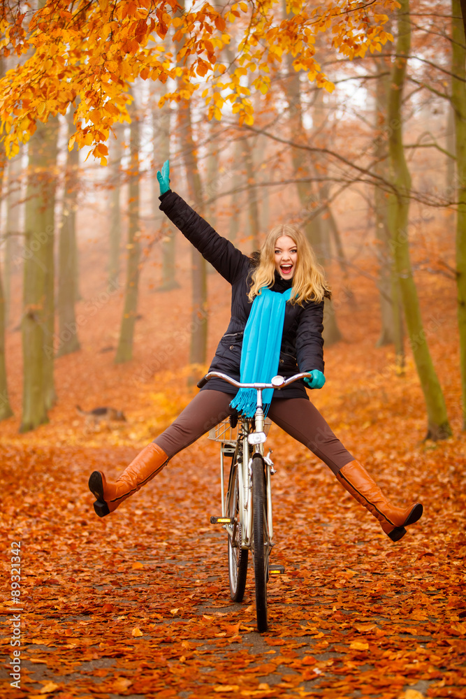 girl relaxing in autumnal park with bicycle