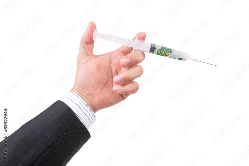 hand holding syringe filled with currency hand holding syringe filled with currency