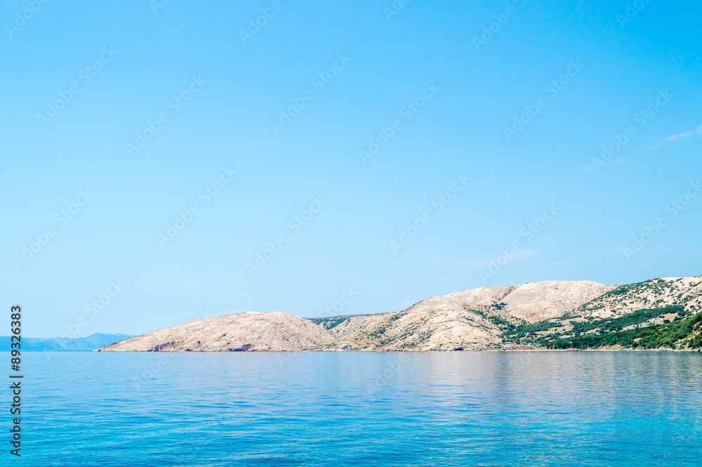 Rocky hills landscape with clear blue sea on a bright summer day Rocky hills landscape with clear blue sea on a bright summer day