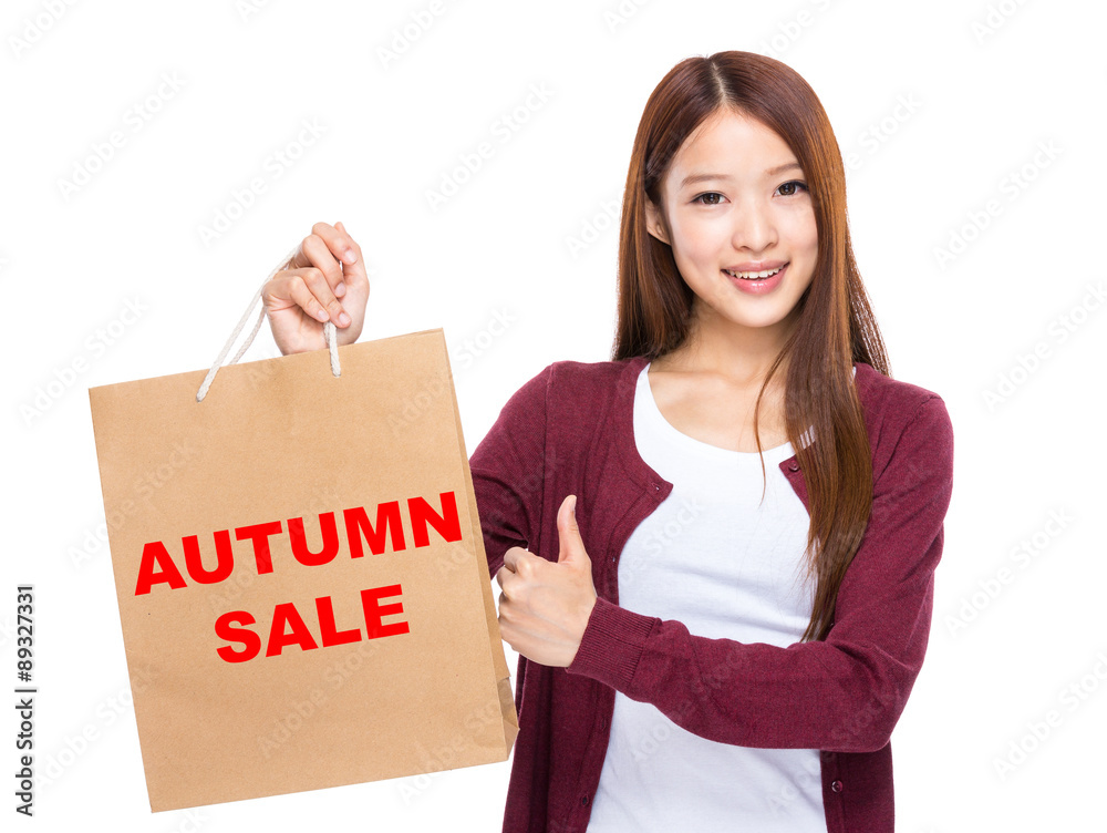 Young Woman hold with shopping bag and thumb up for showing autu Young Woman hold with shopping bag and thumb up for showing autu