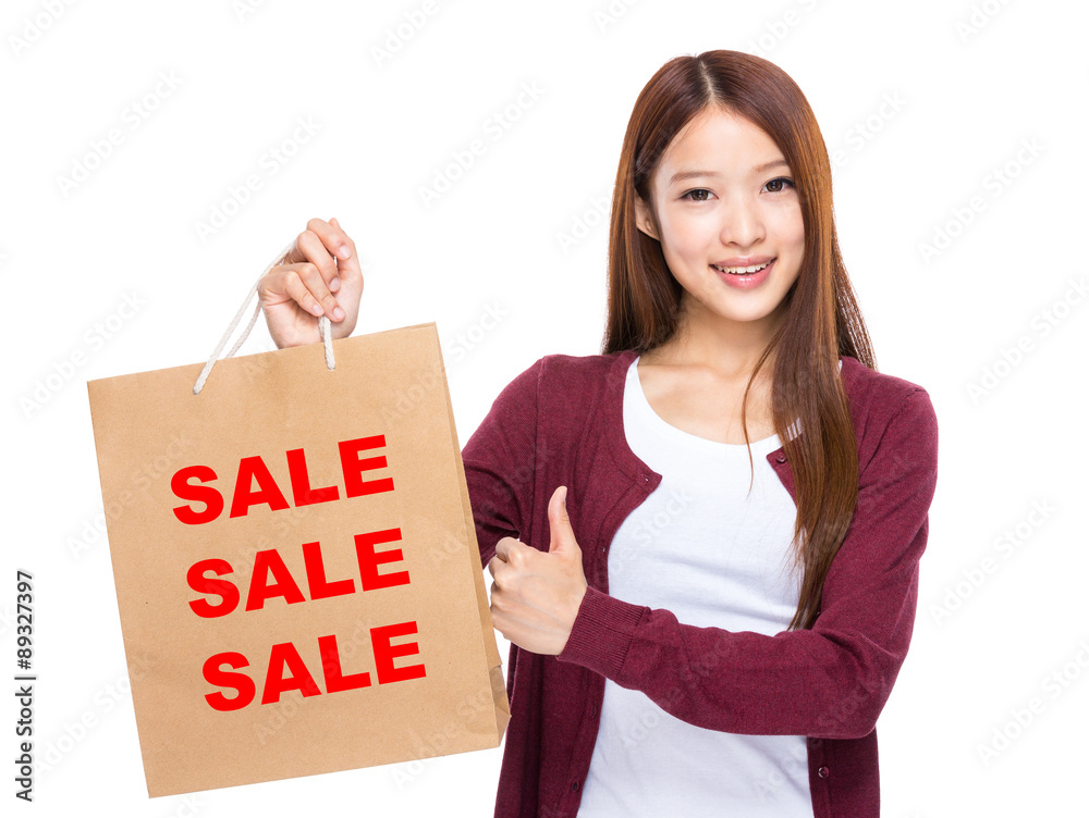 Young Woman hold with shopping bag and thumb up for showing thre Young Woman hold with shopping bag and thumb up for showing thre