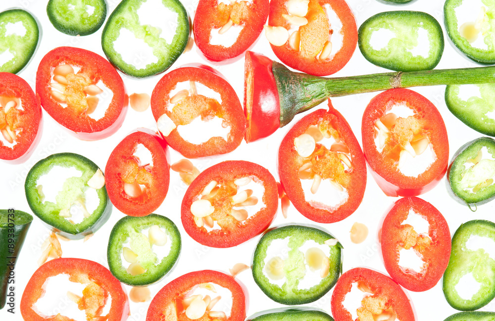 Sliced in pieces red and green chili peppers isolated over white Sliced in pieces red and green chili peppers isolated over white