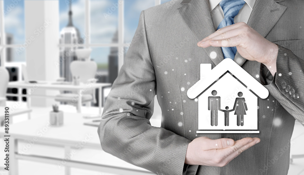 businessman protecting family in home with hands businessman protecting family in home with hands