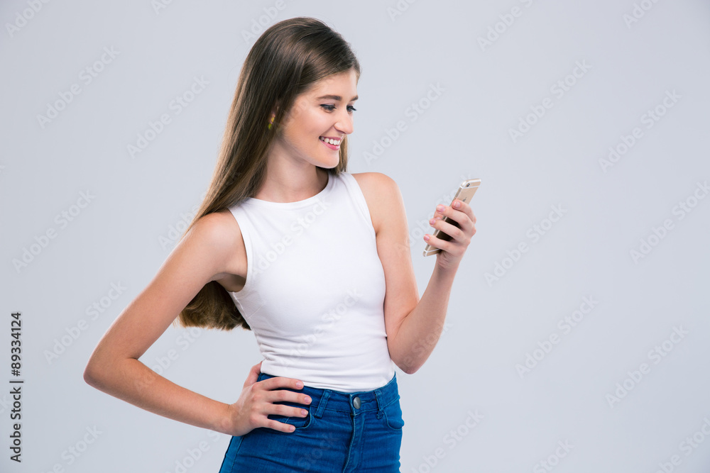 Smiling female teenager using smartphone Smiling female teenager using smartphone