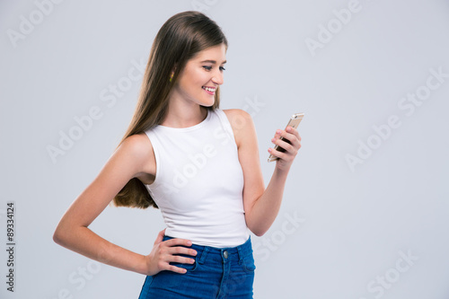 Smiling female teenager using smartphone