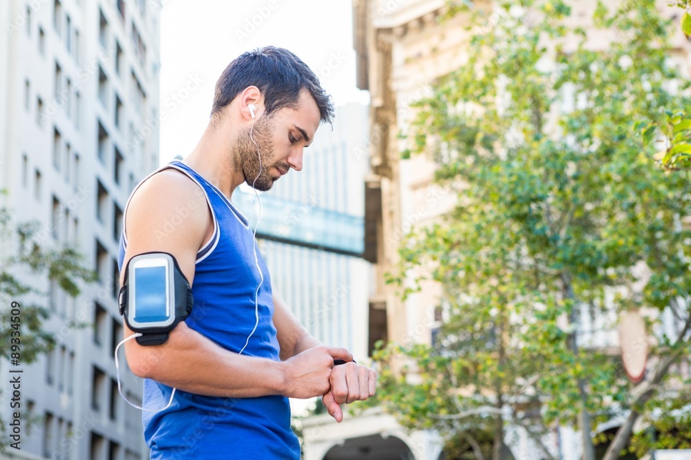 Handsome athlete setting heart rate watch Handsome athlete setting heart rate watch