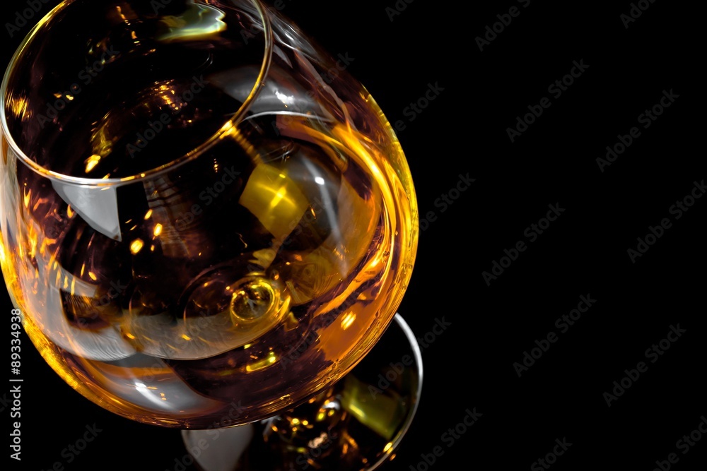 snifter of brandy in elegant typical cognac glass on black background