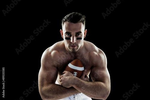 Shirtless American football player with ball © WavebreakMediaMicro