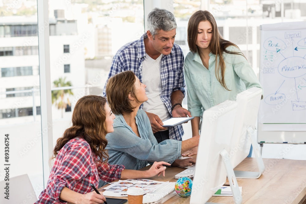 Fototapeta premium Four casual colleagues using computer