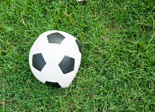 Deflated soccer ball on grass
