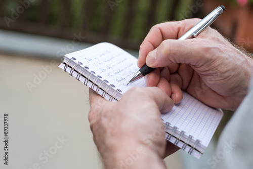 Fotótapéta Man taking notes on a pocket book