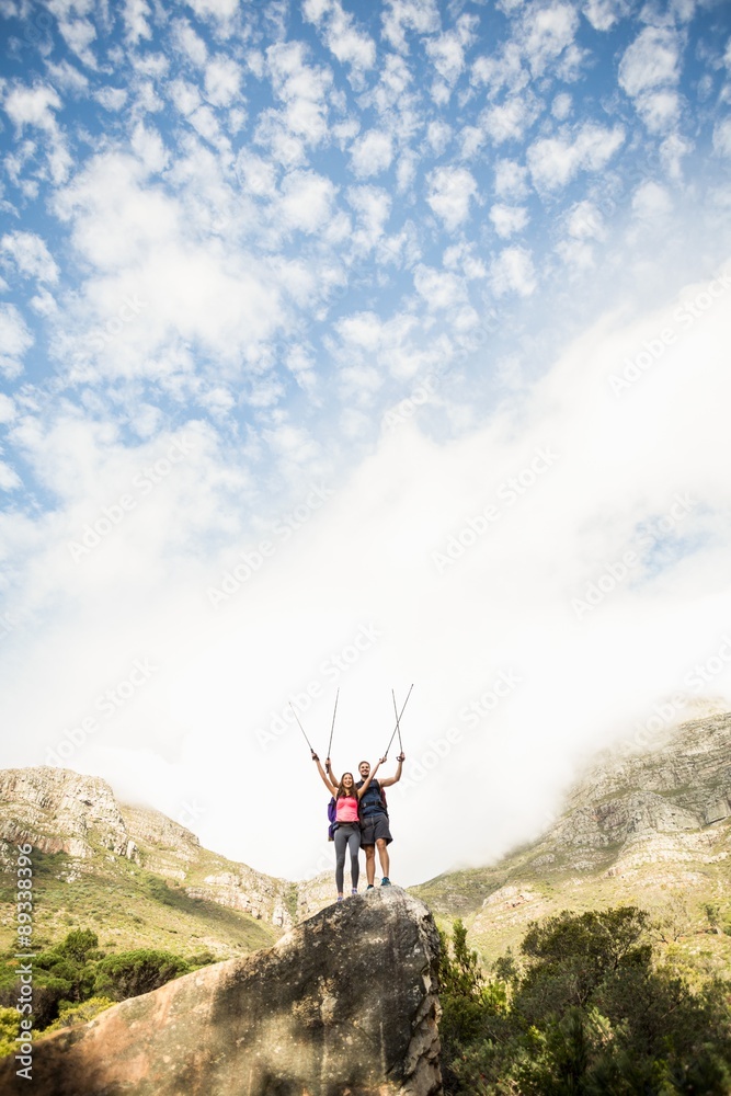 Young happy joggers standing on rock cheering Young happy joggers standing on rock cheering