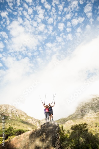 Young happy joggers standing on rock cheering
