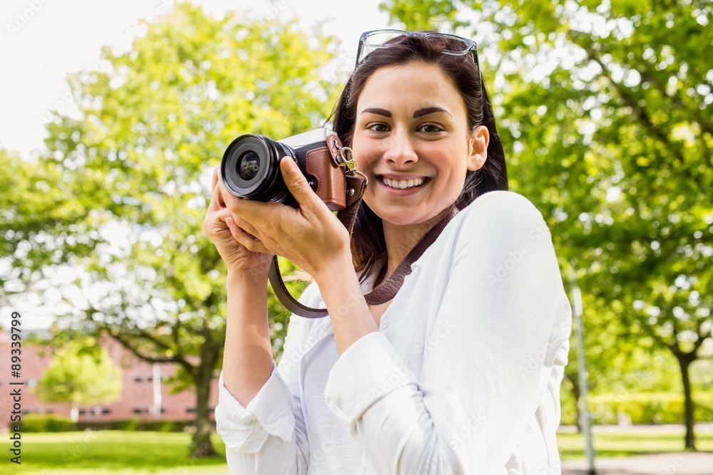 Beautiful brunette taking photo in the park Beautiful brunette taking photo in the park
