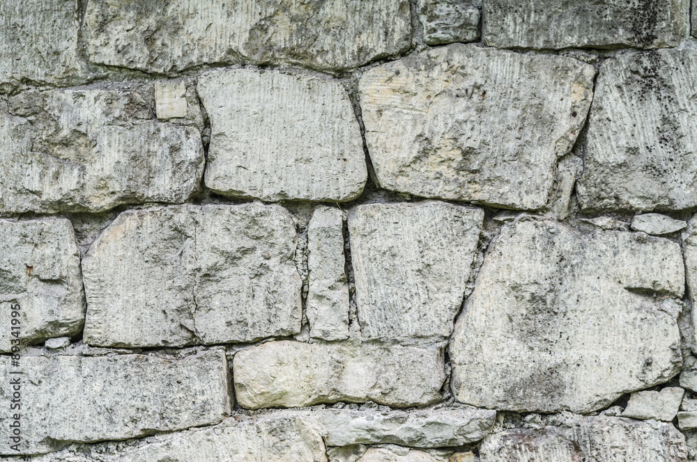 Fototapeta premium Stone wall background made up from different sizes of limestones